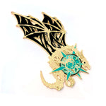 Gold and black dragon-shaped pin with teal accents on a white background
